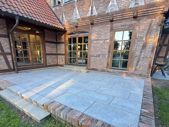 Terrasse aus Granitplatten vor Fachwerkhaus